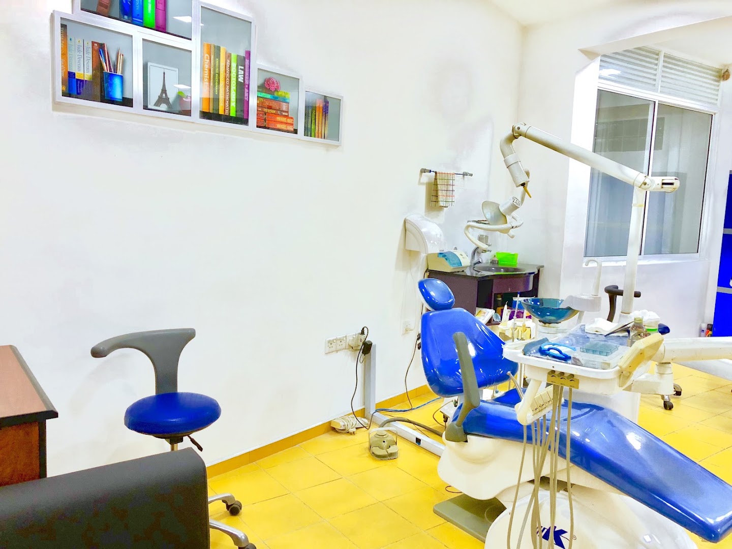 Dental treatment room with a blue chair and equipment